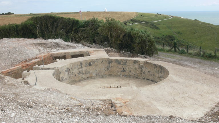 Image of a circular concrete structure with a concrete pit in the middle and the gun holding down bolts in the centre of the pit